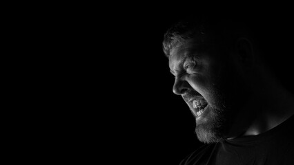 Angry looking Caucasian adult male looking sideways.