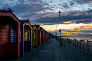 multi coloured sea huts light by a summer sunset