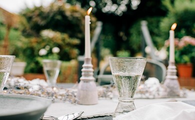 candles burning and wine glass on a decorated dinner table