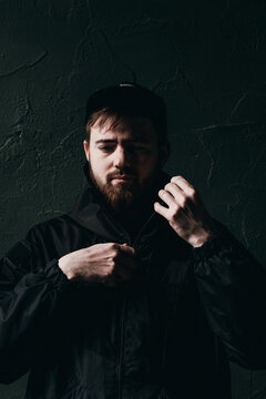 young man unzips his black jacket