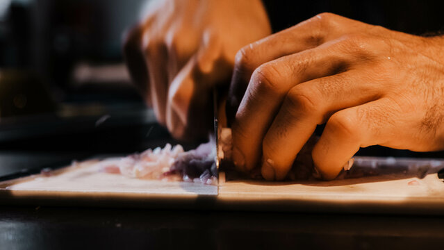 Man cutting onion in a kitchen