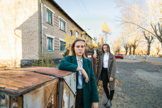 Two friends walk outdoors in autumn, girls stand near  mailbox