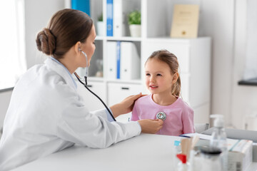 Fototapeta premium medicine, healthcare and pediatry concept - female doctor or pediatrician with stethoscope and little girl patient on medical exam at clinic