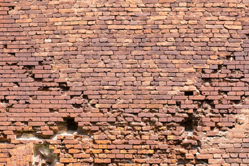 An old brick wall with various damages