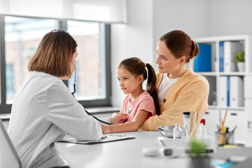 medicine, healthcare and pediatry concept - mother with little daughter and doctor with stethoscope at clinic