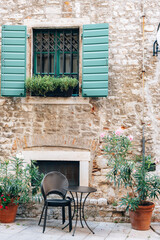 Window with green shutters and table of the street cafe in Sibenik, Croatia