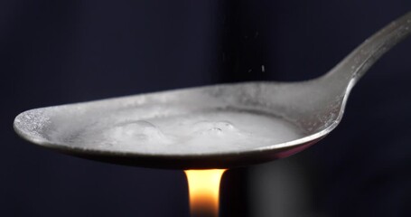 cooking with a lighter a narcotic substance on a spoon, boiling crystal drugs High quality 4k footage - Powered by Adobe