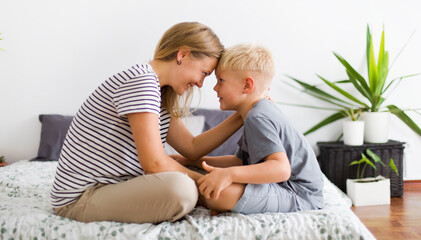 lovely emotional scene with happy mother and son in bedroom