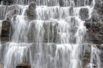 Fototapeta na wymiar A man-made rockery waterfall landscape in the park