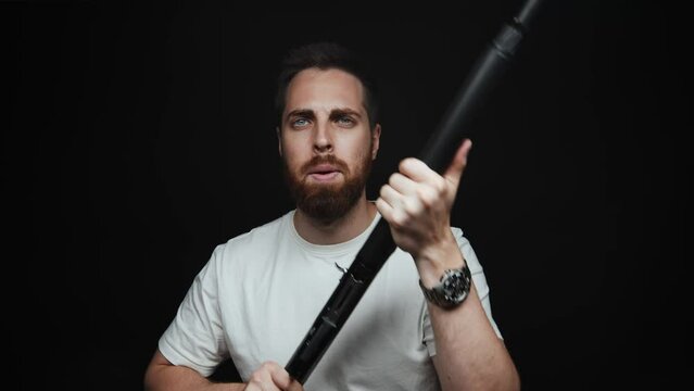 Close-up of a man holding a shotgun and looking at the camera