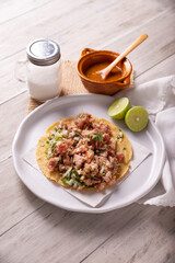 Taco de Carnitas. Cornmeal tortilla with deep fried pork. Traditional Mexican appetizer commonly accompanied by cilantro, onion and hot sauce.