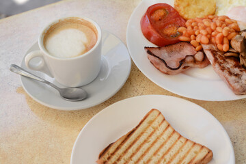 Delicious breakfast with fried meat and vegetables served on beige table