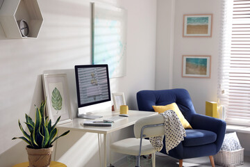 Comfortable office chair near desk with modern computer indoors