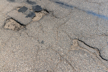 An old paved road with a lot of holes and damage