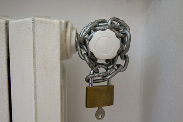 Image of a padlocked chain on a radiator knob. Reference to the rising cost of the price of gas for...