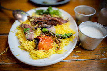 Yellow rice with meat. roasted tomato and onion toppings