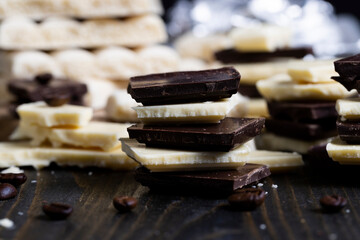 broken into pieces tiles of white and milk and dark chocolate