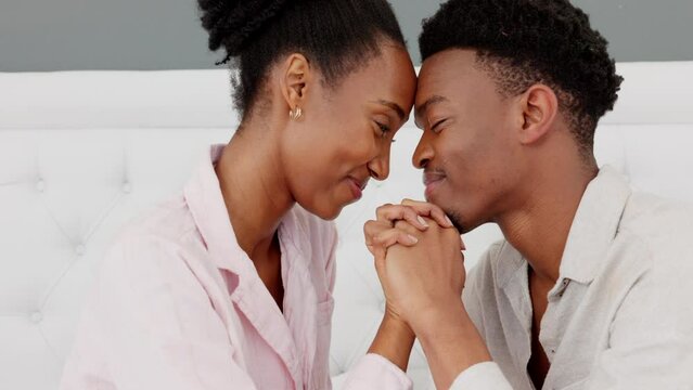 Black couple, love and hands in trust, support or hope in home bedroom, honeymoon hotel or luxury hospitality house. Smile, happy or relax man or woman bonding in forehead touch in security or safety