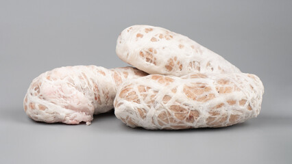 raw cutlet meatballs in pork intestine on gray background
