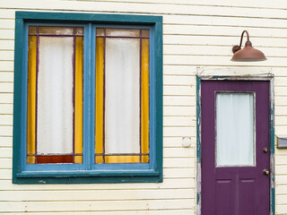 Purple door and color window in wooden exterior wall