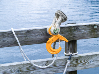 Yellow industrial sling hook hang on wooden railing