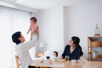 赤ちゃんに高い高いをするお父さん