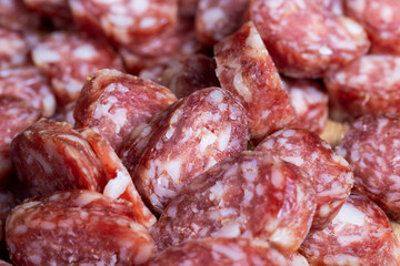 sliced thin sausage with bacon on a wooden dish