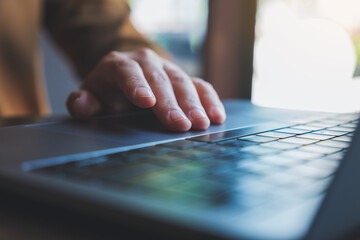Closeup image of a hand working and touching on laptop computer touchpad
