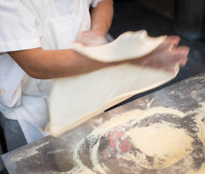 Chef preparing a traditional wood fired pizza