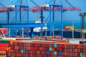 loading containers onto the ship, industrial seaport infrastructure, commercial dock and container warehouse, sea, cranes and cargo ship, concept of sea cargo transportation