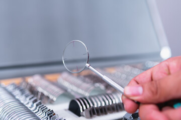 High quality photography. Close up of a hand accommodating a lens in a briefcase full of lenses with different prescriptions.