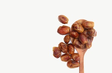Top View of Phoenix Dactylifera Fruit or Date Palm Fruit in Wooden Ladle Isolated on White Background with Copy Space for Texts