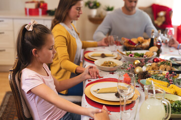 Multi generation caucasian family sitting at table for christmas dinner together