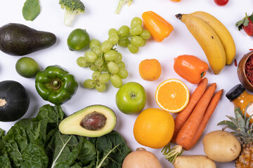 Directly above shot of various healthy fruits and vegetables on white background, copy space