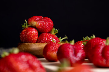 Ripe red strawberries lying on a wooden tray
