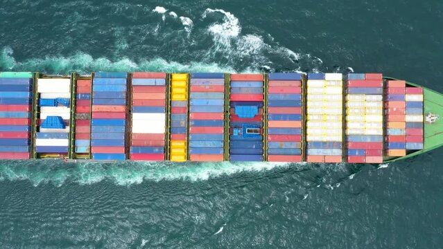 cargo container ship full speed in sea to export goods and distributing products to dealer and consumers across Asia pacific and Europe. by container ship Transport business service.4k video top view 