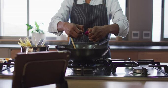 Video of midsection of biracial woman preparing meal