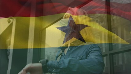 Animation of flag of ghana waving over caucasian woman wearing face mask in city street - Powered by Adobe