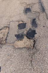 An old paved road with a lot of holes and damage