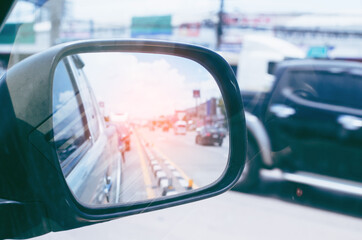 Cars run through the street from the Gray car's side view mirror.  city beside. Road Car Rear View Mirror Motion Blur Background (Vintage Style)