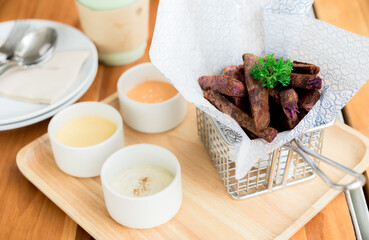 fried Japanese purple sweet potato with dips sauce in a wooden tray