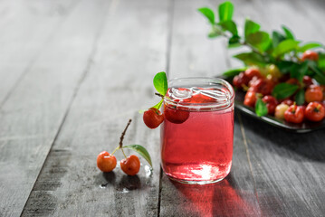 Glass of sour cherry juice with fresh red cherries, Cherry juice, on wood background, red drink, High vitamin C and antioxidant fruits.