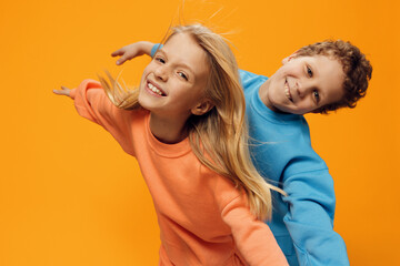 cute, beautiful children are standing on a blue background with an empty space for an advertising...