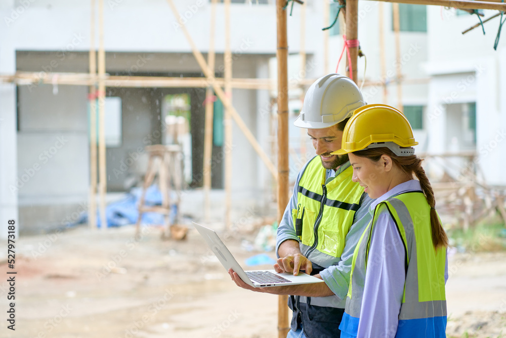 Wall mural Team of foreman are working and discussing by laptop on construction site