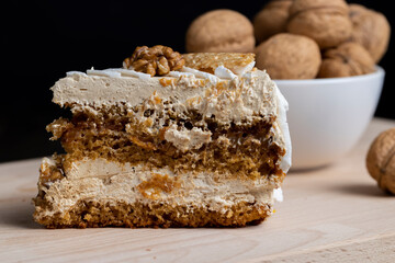 a piece of cake with buttercream and walnuts