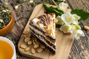 Delicious layered cake with caramel and peanuts on the table