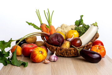 Freshly bunch harvest. Fresh farm vegetables in wicker basket. Healthy organic food, raw carrot, beetroot, potatoes and tomatoes.