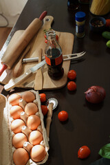 Shot of some veggies and eggs at table in kitchen. Ingredients of future pizza.