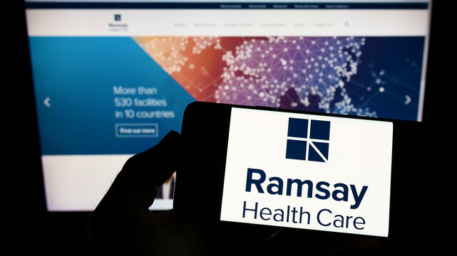Stuttgart, Germany - 08-27-2022: Person holding smartphone with logo of Australian company Ramsay Health Care Limited on screen in front of website. Focus on phone display.