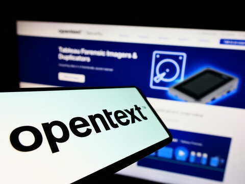 Stuttgart, Germany - 08-27-2022: Smartphone with logo of Canadian software company OpenText Corporation on screen in front of business website. Focus on center of phone display.